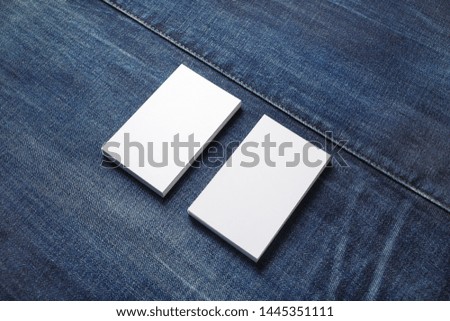 Blank white business cards on denim background. Mockup for branding identity. Template for graphic designers portfolios.