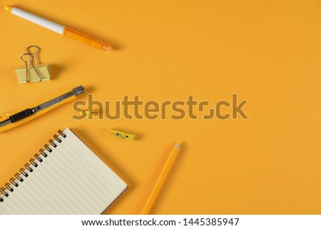 Top view of stationery or school supplies with books, color pencils and clips on yellow tone background. Education or Back to school concept.