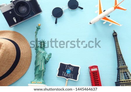 holidays image of traveling concept with accessories and world symbols over blue background. top view, flat lay