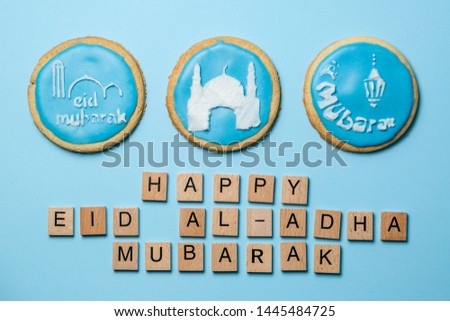 Eid Al-Adha Mubarak holiday concept - blue cookies with stenciled pictures, top view