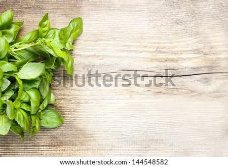 Basil leaves on wooden background. Copy space