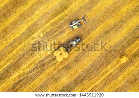 Harvesting machine working in the field. Top view from the drone
