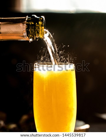 Fizzy pouring close up of champagne mimosa cocktail Royalty-Free Stock Photo #1445539817