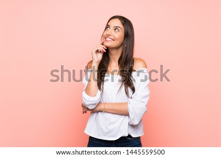 Young woman over isolated pink background thinking an idea while looking up
