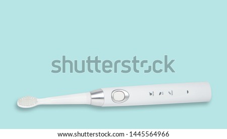 White sonic toothbrush for cleaning teeth on a blue pastel background. Medical and dental concept. Caring for teeth, modern methods of removing calculus from teeth. Electric toothbrush.