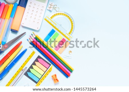 Back to school concept with colorful school supplies border on blue background with copy space