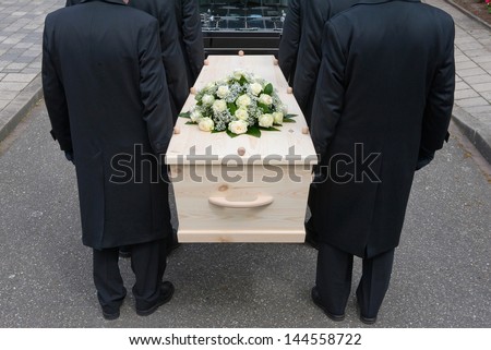 Bearers a carrying a coffin into a car Royalty-Free Stock Photo #144558722