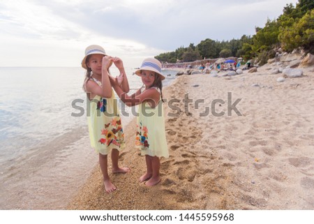 Portrait of adorable happy two little girls on sand beach - Happiness children making hands heart shape - summer holiday 