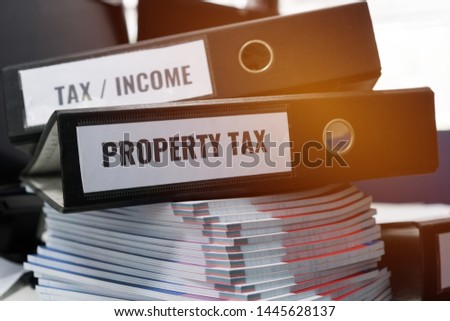 Financial Document Reports Concept,Tax return and property tax folders stack with label on black binder on paperwork documents summary report in busy offices. HR-human resources business accountancy