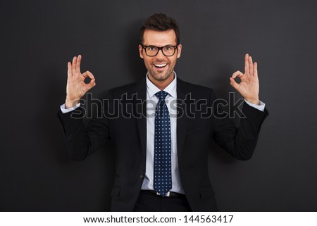 Happy businessman wearing glasses showing OK sign