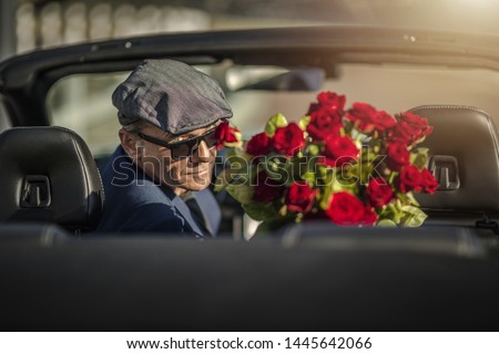 Sugar Daddy Eyes Seduction. Attractive Caucasian Men with Roses Awaiting His Girlfriend While Seating in a Convertible Car. Royalty-Free Stock Photo #1445642066