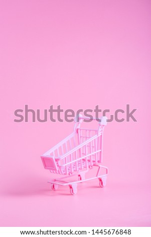 Shopping cart over pink background
