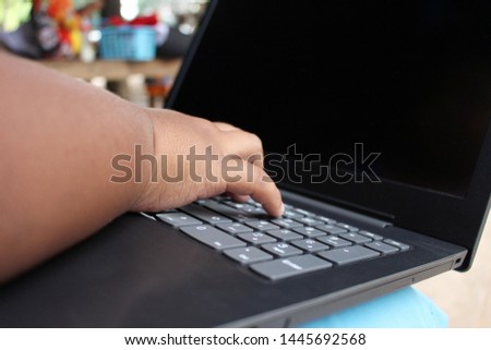 The little boy is doing his homework on the computer, taking a blurred picture