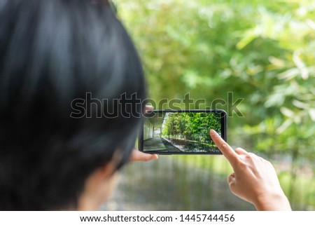 modern Asian woman take a picture by cellphone at a corridor