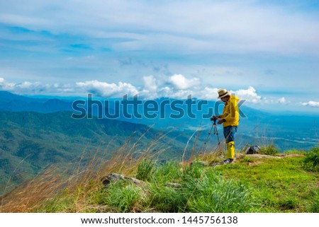 Tourists stand to take pictures at the viewpoint with mountains and beautiful skies, the rainy season of Southeast Asia.