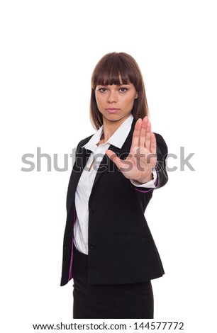 Serious business woman making stop hand sign, businesswoman in black suit isolated over white background