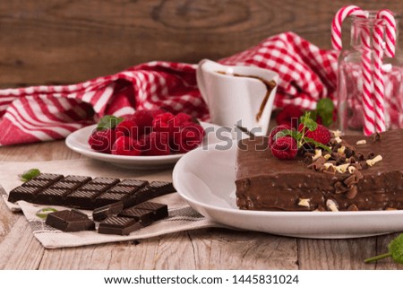 Chocolate cake with raspberries on white dish.