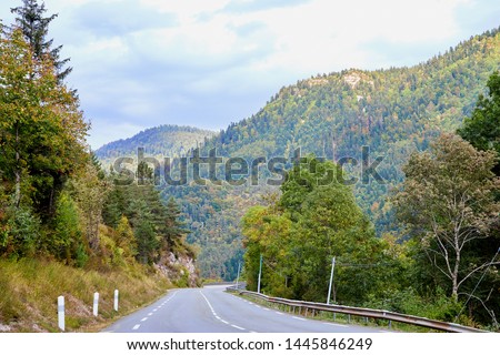 Road in a mountain in a summer day with white white clouds. Beautiful mountain landscape