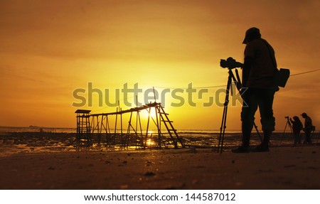 a silhouette of a photographer in action