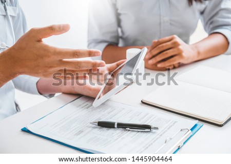 Doctor with patient presenting about Treatment guidelines on digital tablet at office Royalty-Free Stock Photo #1445904464