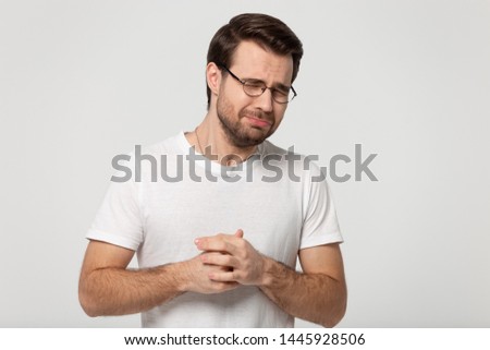 Man wearing glasses white t-shirt closed eyes being under pressure stress screaming or whines standing isolated on grey studio background, nagging man feeling desperate, loser unhappy person concept Royalty-Free Stock Photo #1445928506