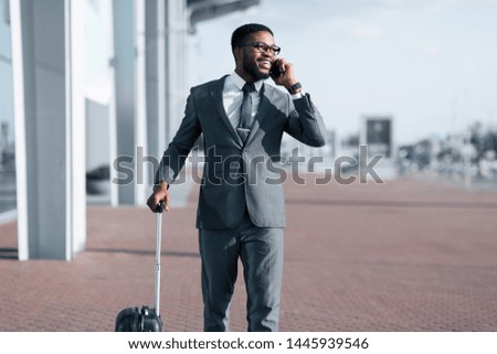 Call Taxi. African Businessman Arriving To Airport And Talking On Phone