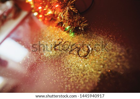 Festive figure 2020, written on a claret background with sparkles. New Year's concept