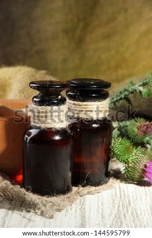 Medicine bottles and mortar with thistle flowers