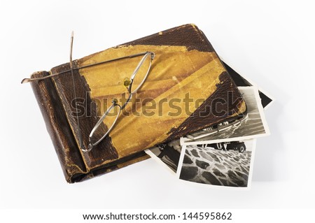 Old photo album. An old photo album with a pair of glasses on it in white background