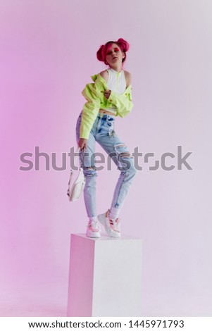 woman with pink hair in stylish clothes is standing in the cube of fashion
