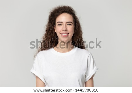 Head shot portrait young 20s woman having wide white smile wearing t-shirt looking at camera, pretty female advertise good offer teeth whitening in dental clinic posing isolated on grey background