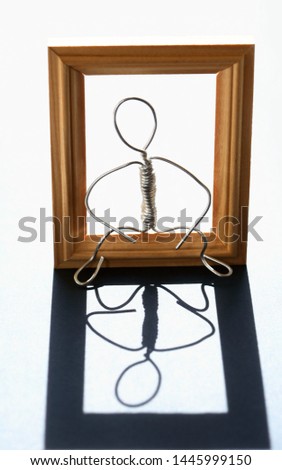 Man made from aluminum wire inside wooden picture frame