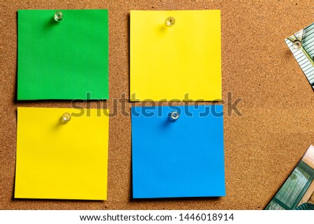 Corkboard/Bulletin Board and blank Sticky Notes in Yellow, Green and Blue, arranged in a very orderly fashion.  Great for Copywriting.