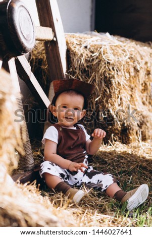 Little cowboy sitting on hay