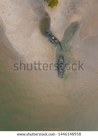 Aerial close up view of broken fisherman's boats stranded by the beach. Shipwreck, worn naturally