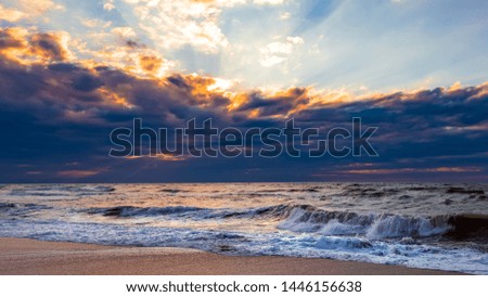 Beach with waves at colorful sunset