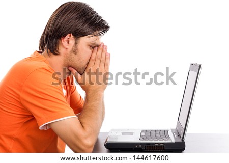 Sad young man  looking at his laptop against white