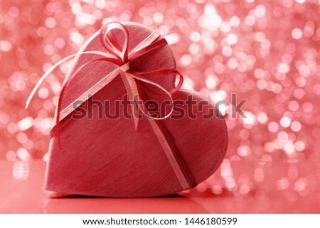 Heart shaped wooden gift box against holiday background. Living Coral color toned image