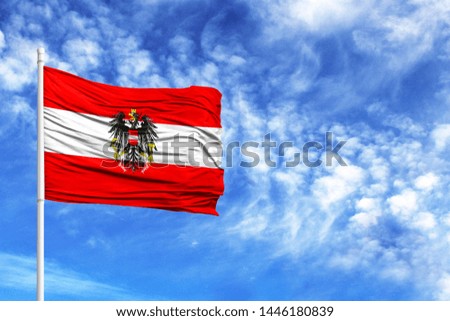 National flag of Austria on a flagpole in front of blue sky