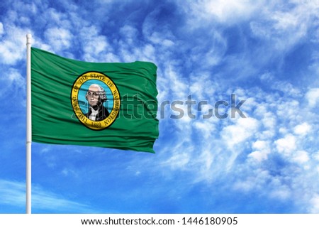 National flag State of Washington on a flagpole in front of blue sky