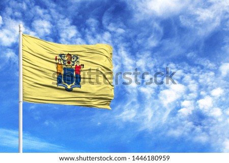 National flag State of New Jersey on a flagpole in front of blue sky