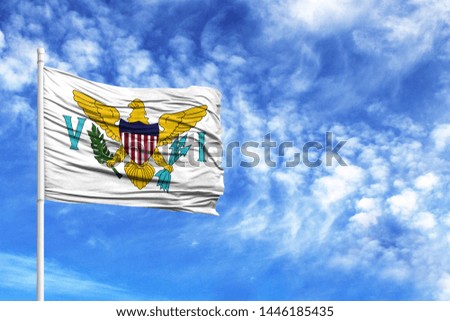 National flag of Virgin Islands of the United States on a flagpole in front of blue sky