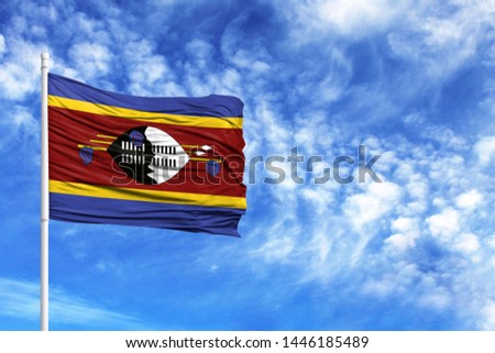 National flag of Swaziland on a flagpole in front of blue sky