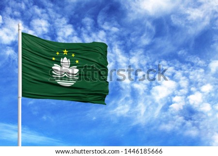 National flag of Macau on a flagpole in front of blue sky