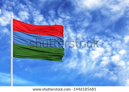 National flag of Karelia on a flagpole in front of blue sky