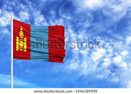 National flag of Mongolia on a flagpole in front of blue sky
