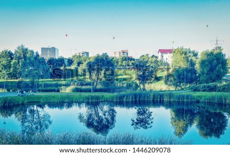 EU Natural park with pond in the city. Hot air balloons on the background. Vilnius. Toned
