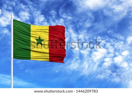 National flag of Senegal on a flagpole in front of blue sky