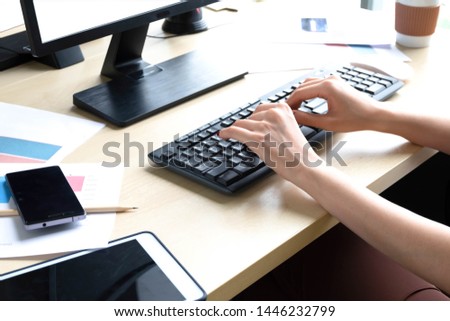 Close up woman hands.Hands working woman typing on the keyboard on wooden table at office.Business woman are very busy.Smartphone and tablet on the wooden table.
