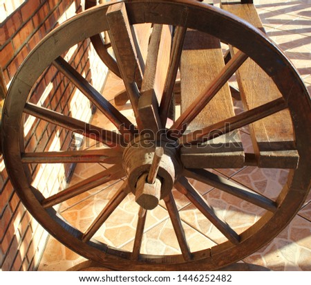 rustic wooden bench made with large wheels on its sides